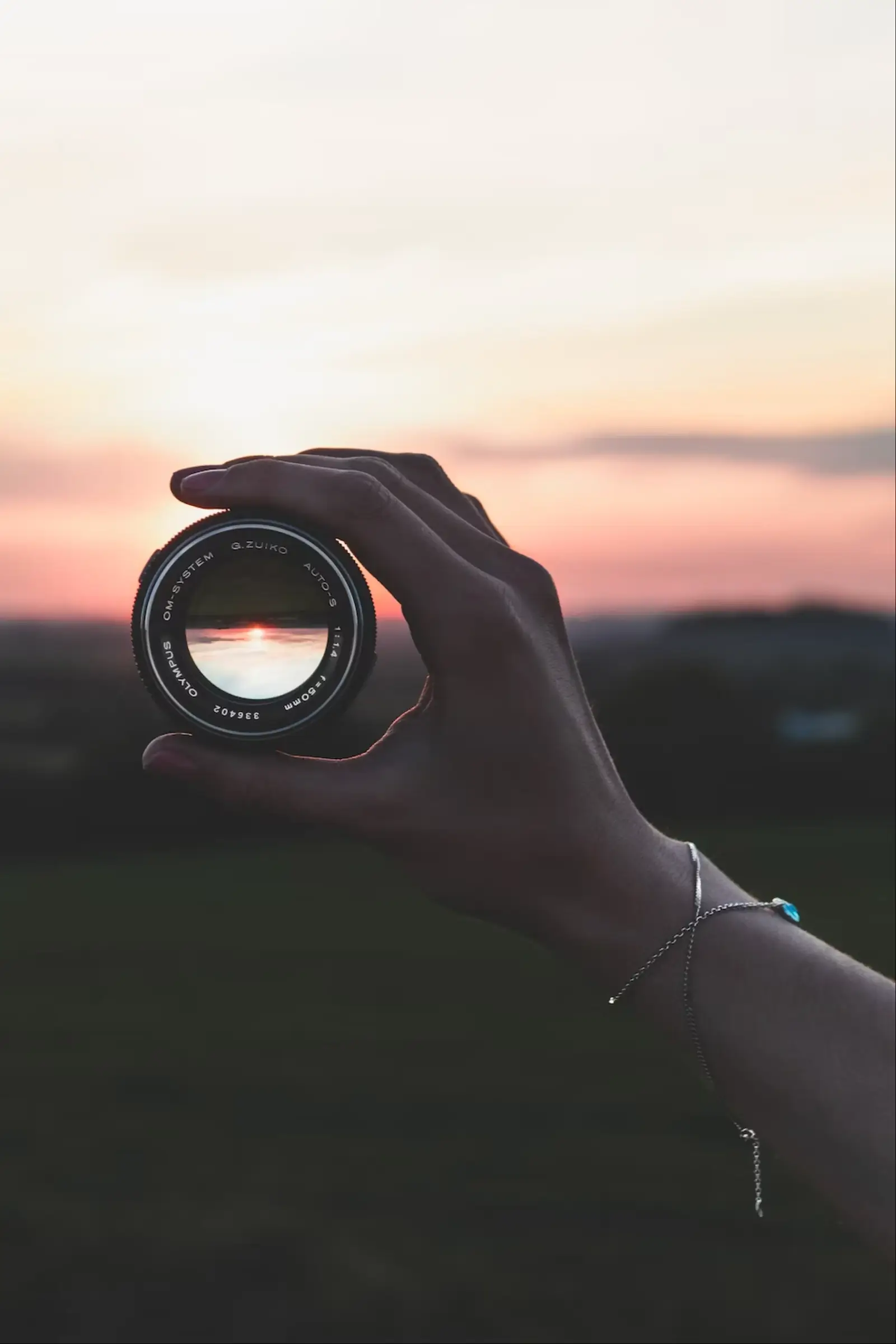 A camera lens held up to a sunset